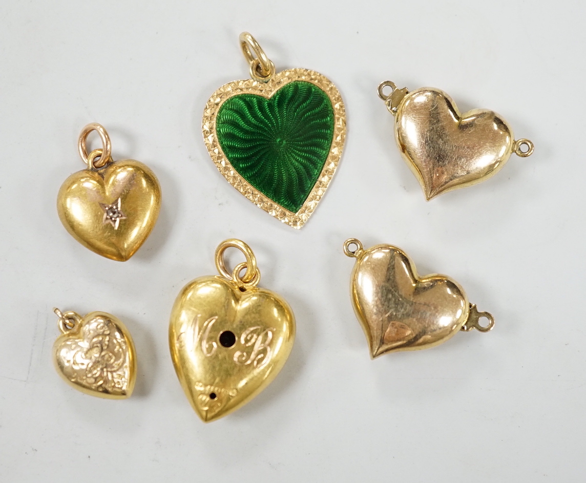 Two late Victorian 15ct and single stone diamond set heart pendants, largest 19mm, gross weight 3.1 grams, four other yellow metal heart shaped pendants including one with green enamel.